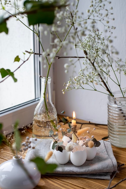 Een kaars staat op een tafel naast een vaas met bloemen.