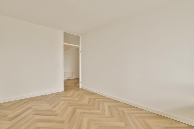 Een kamer met een houten vloer en witte muren