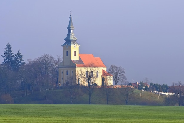 Een kerk op een heuvel met een toren en een toren op de voorgrond