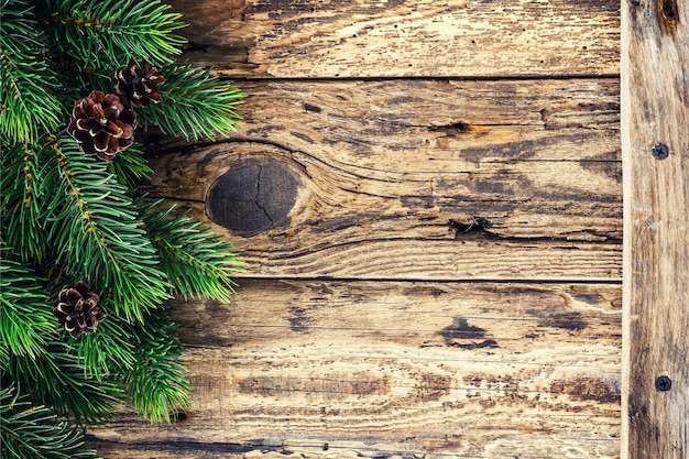 Een kerstboom met een tak van sparren op een houten achtergrond