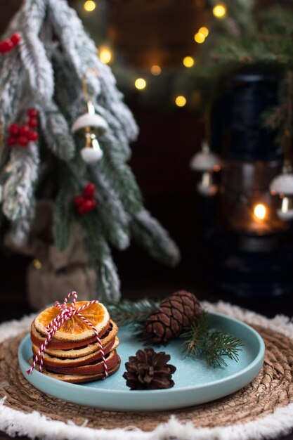 Foto een kerstboom met speelgoed en een bord met rode viburnum bessen en sinaasappel plakjes nieuwjaarsverlichting