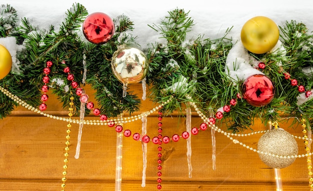 Een kerstversiering met ornamenten en een boom op de achtergrond