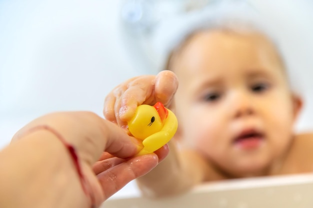 Een kind baadt in een bubbelbad. Selectieve aandacht. Gelukkig.