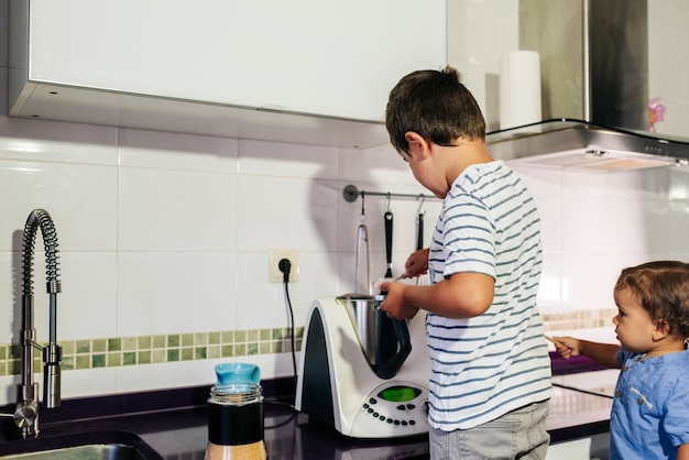 Een kind bereidt pannenkoeken met een keukenrobot.