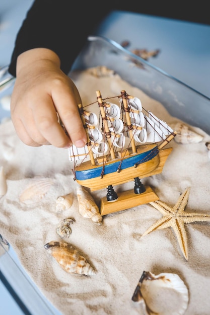 Foto een kind bestudeert zand en schelpen een idee voor een activiteit met een kind