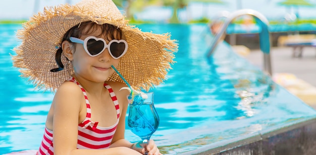 Een kind bij het zwembad drinkt een cocktail