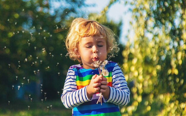 Een kind blaast een paardenbloem Selectieve focus