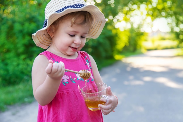 Een kind eet honing in het park Selectieve aandacht