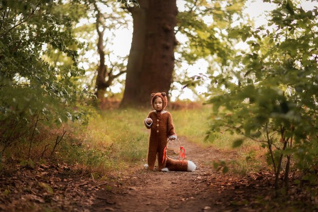 een kind in de vorm van een vos loopt in het bos