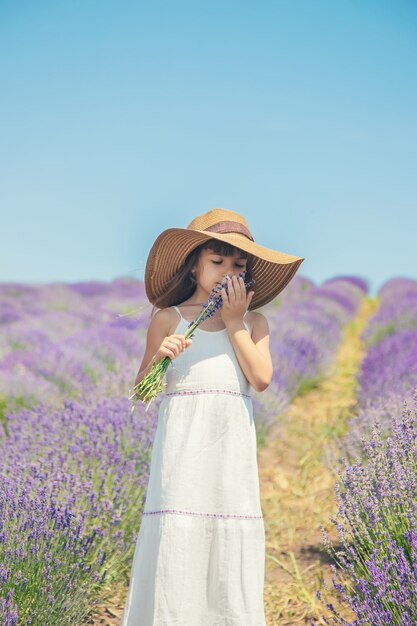 Een kind in een bloeiend veld met lavendel.