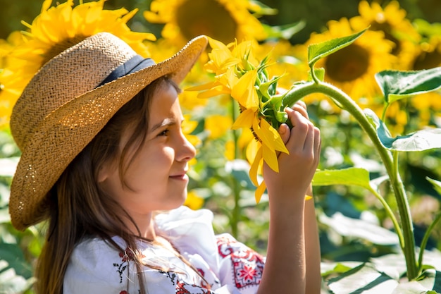 Een kind in een veld met zonnebloemen in een geborduurd hemd. Oekraïne Onafhankelijkheidsdag concept. Selectieve aandacht.