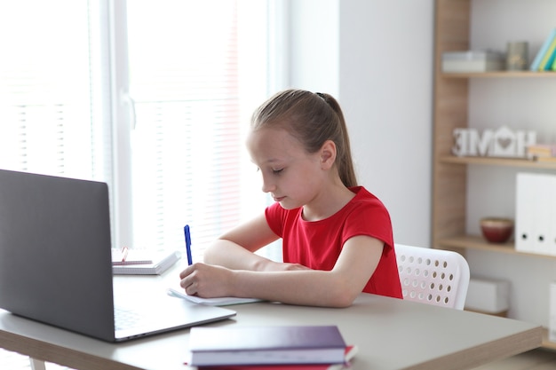 Een kind leert thuis online via een moderne laptop op internet