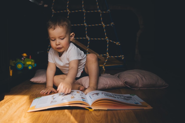 een kind leest thuis een boek op de grond