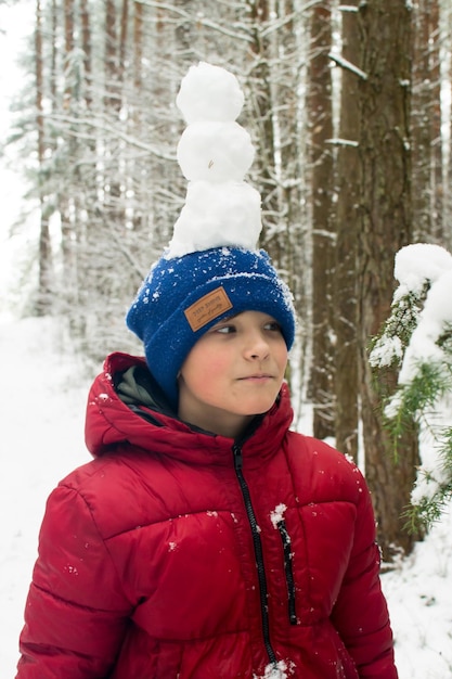 Een kind loopt door een besneeuwd bos. Winterwandeling.