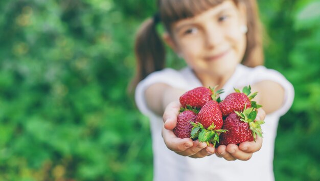 Een kind met aardbeien in de handen