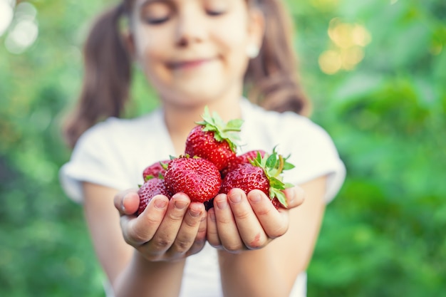 Een kind met aardbeien in de handen