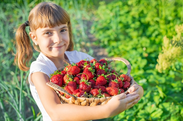 Een kind met aardbeien in de handen