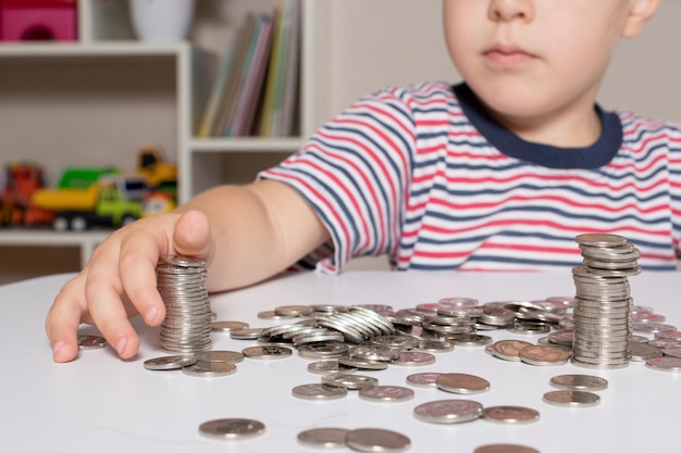Een kind met een bril, een jonge zakenman speelt met munten