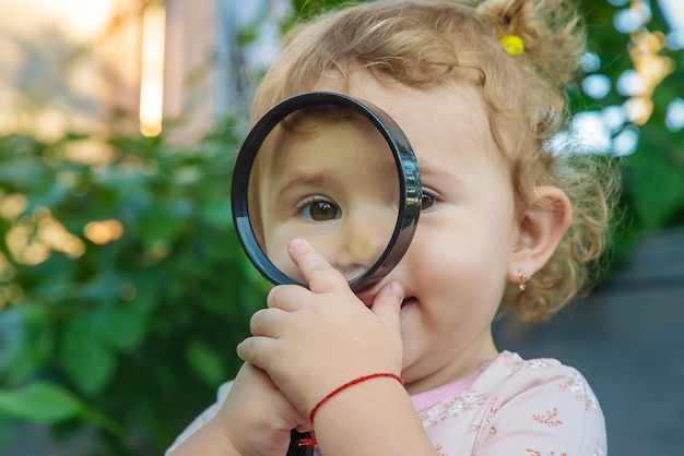 Een kind met een vergrootglas bestudeert de wereld Selectieve focus