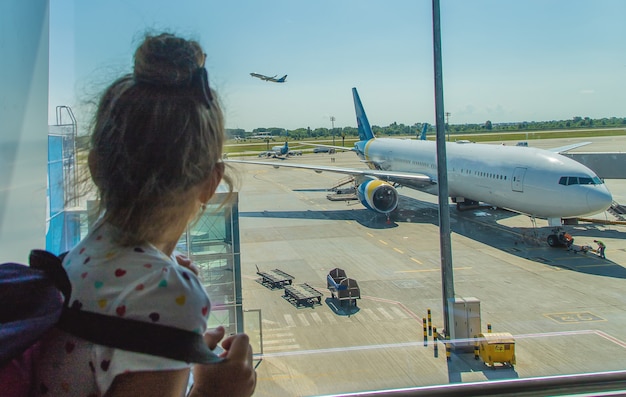 Een kind op de luchthaven op de achtergrond van het vliegtuig