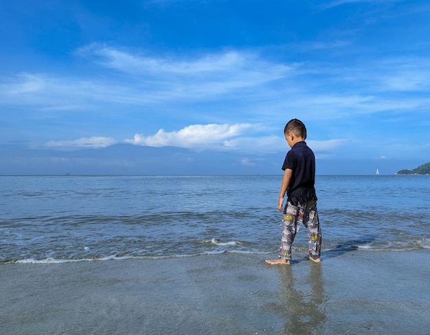 Een kind speelt graag in het zeewater op het strand