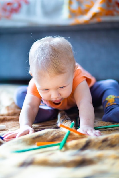 Een kind speelt met regenboogkleurige potloden op een onscherpe achtergrond