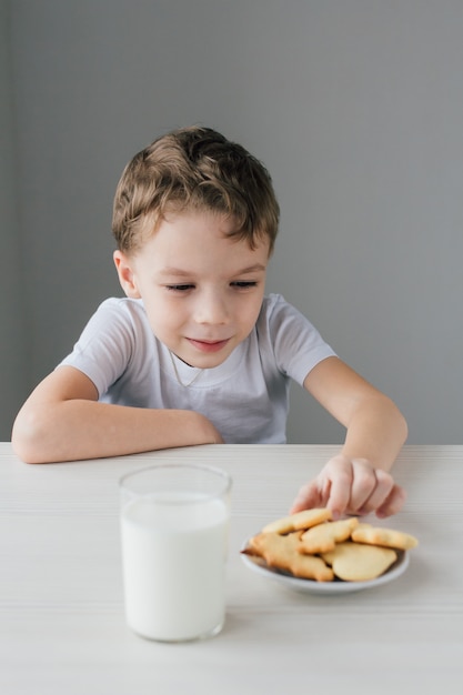 Een kind steelt van een bord versgebakken zelfgemaakte koekjes