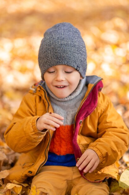 Een kind verheugt zich op het spelen met een lieveheersbeestje in een herfstpark. Gelukkige jeugd