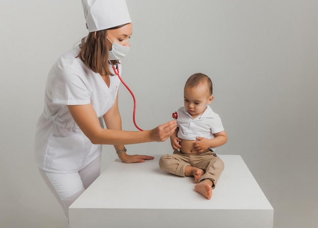 Een kinderarts onderzoekt een eenjarige jongen met een stethoscoop in een ziekenhuiscentrum. gezondheidsconcept