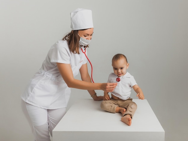 Een kinderarts onderzoekt een eenjarige jongen met een stethoscoop in een ziekenhuiscentrum. gezondheidsconcept