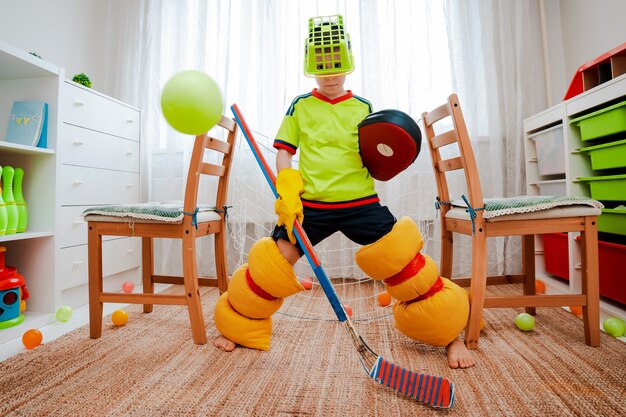 Een kindjongen speelt thuis hockey