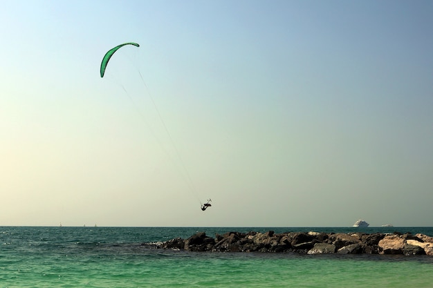 Een kitesurfer neemt over golven en stown spit