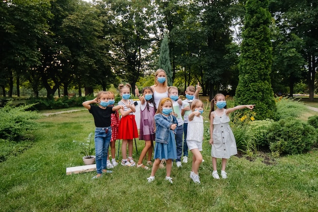 Een klas gemaskerde schoolkinderen is bezig met buitentraining tijdens de epidemie