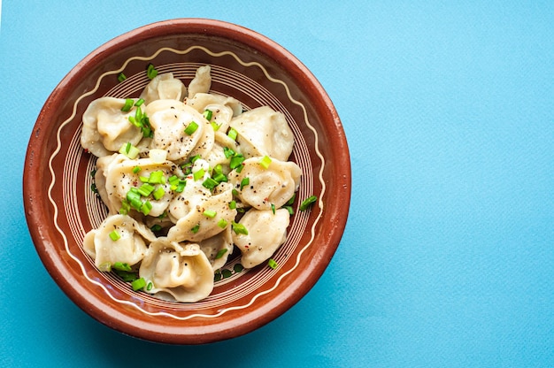 een klassiek traditioneel gerecht van pelmeni-knoedels met vlees, boter, peper en groenten, eten