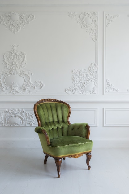 Een klassieke fauteuil tegen een witte muur en vloer. Kopieer ruimte