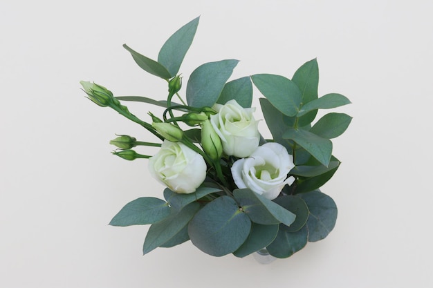 Een klein boeket van witte bloemen met groene bladeren