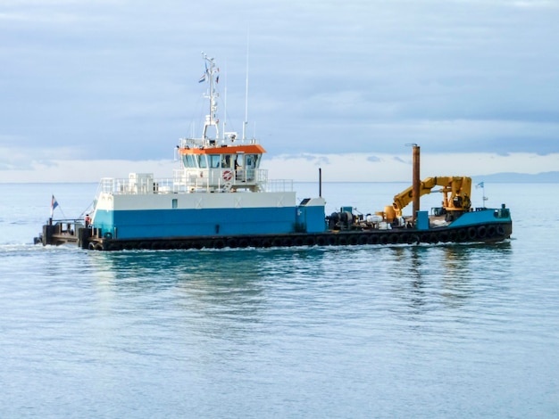 Een klein dienstschip in een industriële vrachthaven Een schip op zee