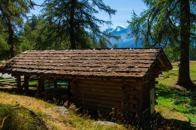 Een klein houten gebouw met een dak waarop staat 'berg op de achtergrond'