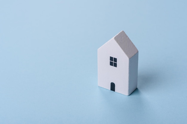 Een klein houten huis en sleutels als idee om in je eigen huis te investeren