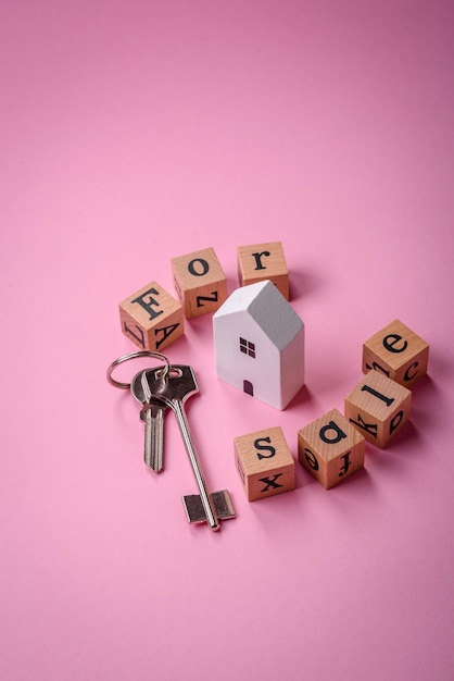 Foto een klein houten huisje en sleutels als idee om in je eigen huis te investeren