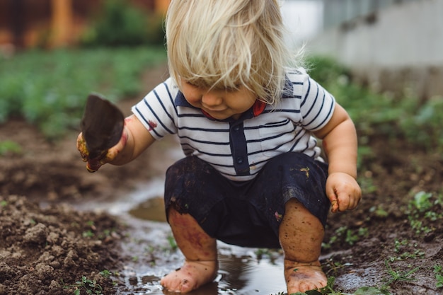 Foto een klein kind een jongen besprenkelt aardbei