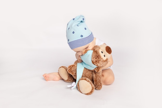 Een klein kind knuffelt een teddybeer op een witte geïsoleerde achtergrond