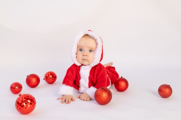 Een klein kind ligt in een kerstman kostuum in de studio