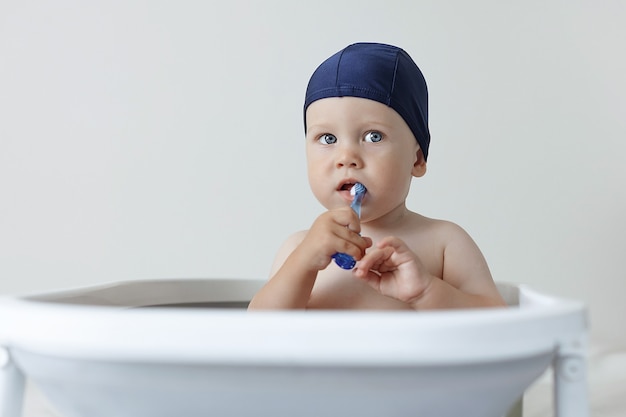Foto een klein kind poetst zijn tanden terwijl hij in de badkamer zit