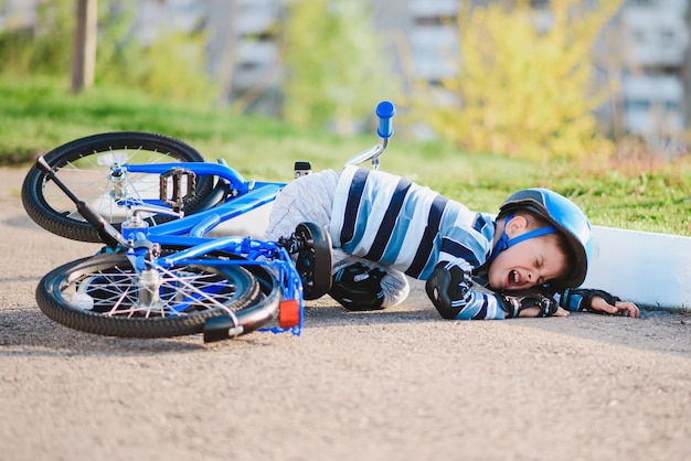 Een klein kind viel van een fiets op de weg, huilend en schreeuwend van de pijn.