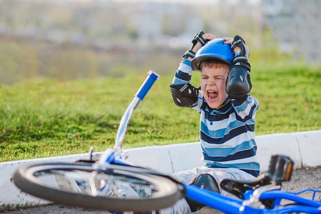 Een klein kind viel van een fiets op de weg, huilend en schreeuwend van de pijn.