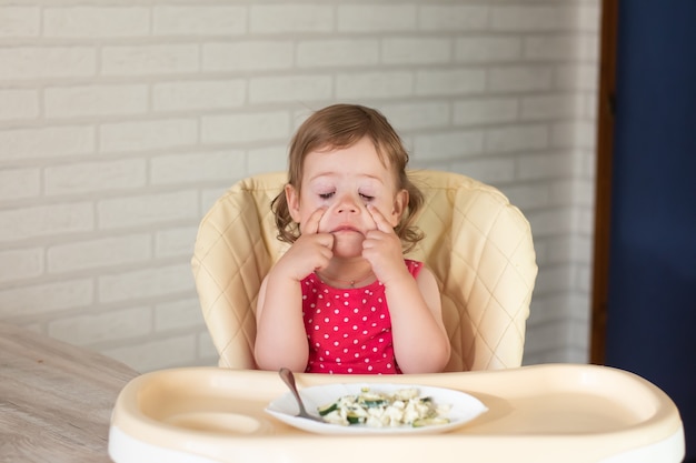 Een klein kind wil geen lasagne met groenten eten en is stout