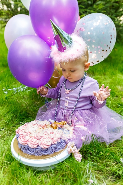 Een klein knap meisje bederft haar eerste cake in het park