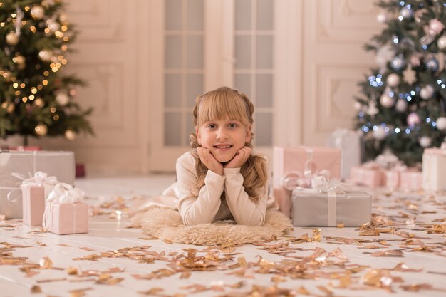 Een klein meisje dat 's ochtends een kerstcadeau van de kerstman vindt