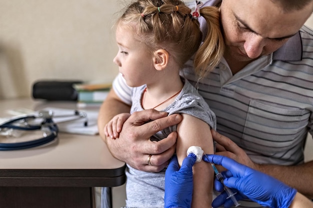 Foto een klein meisje in de artsen het concept van vaccinatie preventie tegen covid-19